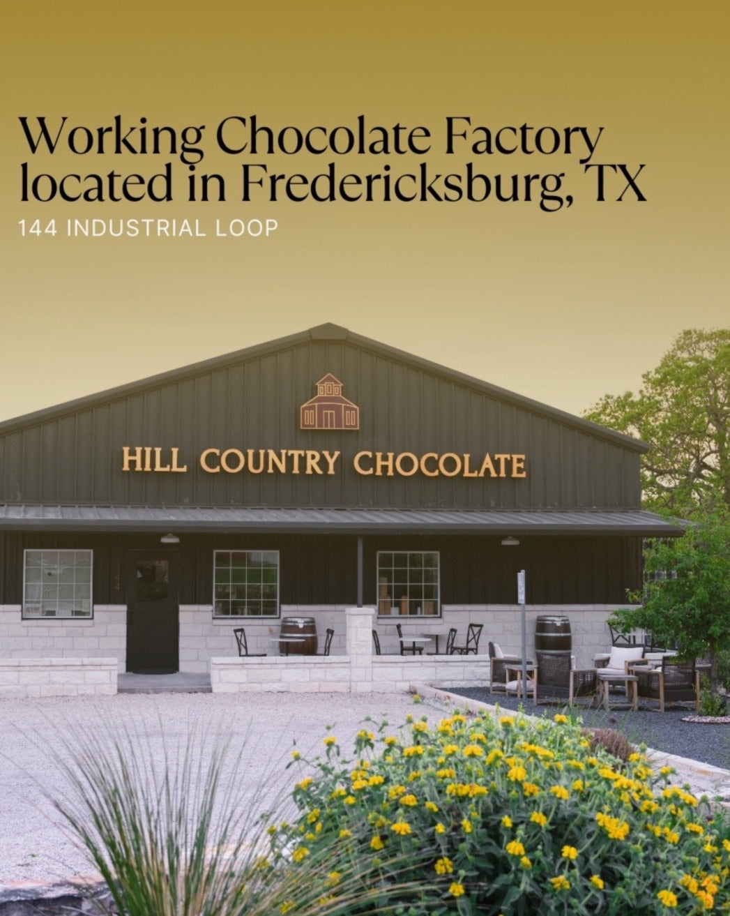 Hill Country Chocolate factory exterior with gray metal and stone, outdoor seating, and yellow flowers at Fredericksburg, TX.