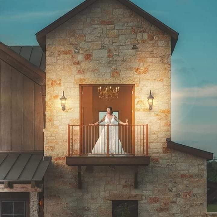 Bride in white lace wedding dress on stone balcony, elegant outdoor bridal fashion photo