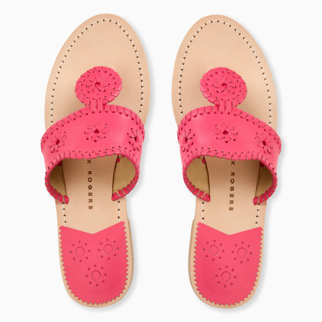 The Zertz JACKS FLAT SANDAL NAPPA for women features light tan soles, bright pink leather straps with decorative stitching, and circular floral cutouts. These flat, open-toed sandals offer all-day comfort and flexibility.