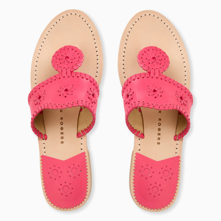 The Zertz JACKS FLAT SANDAL NAPPA for women features light tan soles, bright pink leather straps with decorative stitching, and circular floral cutouts. These flat, open-toed sandals offer all-day comfort and flexibility.
