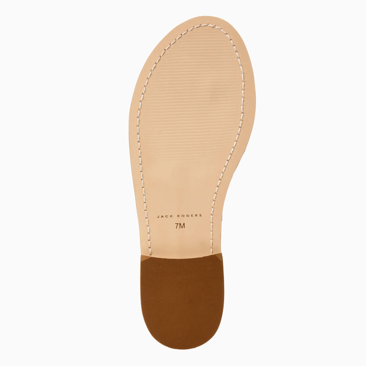 The image shows the sole of a light tan Zertz JACKS FLAT SANDAL NAPPA with visible edge stitching, a brown heel, and "JACKS FLAT SANDAL NAPPA 7M" at the center, highlighting its improved flexibility for all-day comfort.