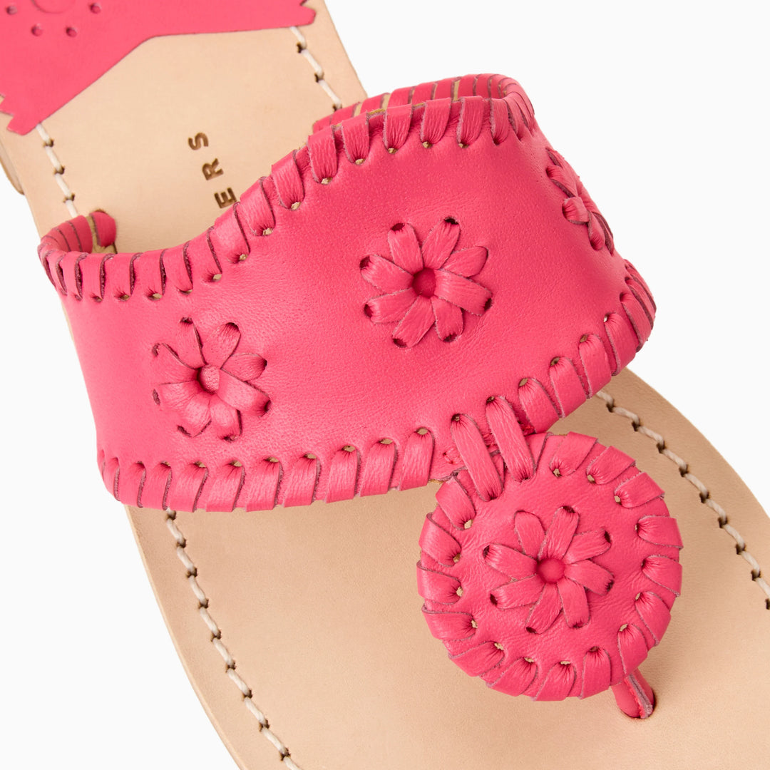 Close-up of the Zertz JACKS FLAT SANDAL NAPPA, featuring a tan leather sole and hot pink leather upper strap with stitched flower designs and a matching pink circular accent near the toe for added comfort and flexibility.