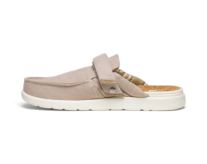 The Zertz M HAPPY HOUR LITE RESORT 1169850 is a beige, water-repellent slip-on mule featuring a canvas upper, cushioned white SugarLite outsoles, patterned fabric heel lining, and a stylish side strap with metal button accent.