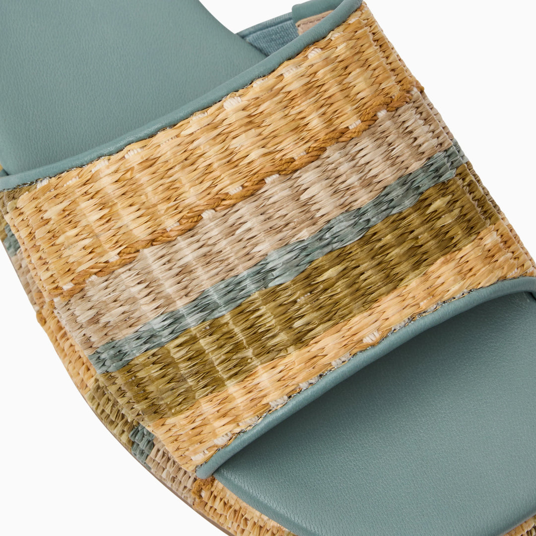 Close-up of the Zertz BAY FLATFORM-RAFFIA shoes, ideal for beach vacations, with a blue-green footbed and a wide woven strap in beige, cream, olive, and green stripes featuring a natural raffia texture.