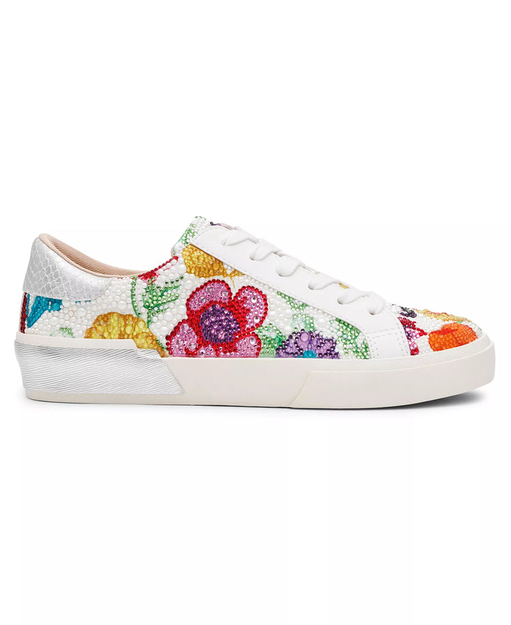 The Zertz DAMON SNEAKER SB-DAMNON features a white lace-up design with a textured surface and vibrant red, yellow, purple, and green floral embroidery on the side and toe, set against a plain white background.