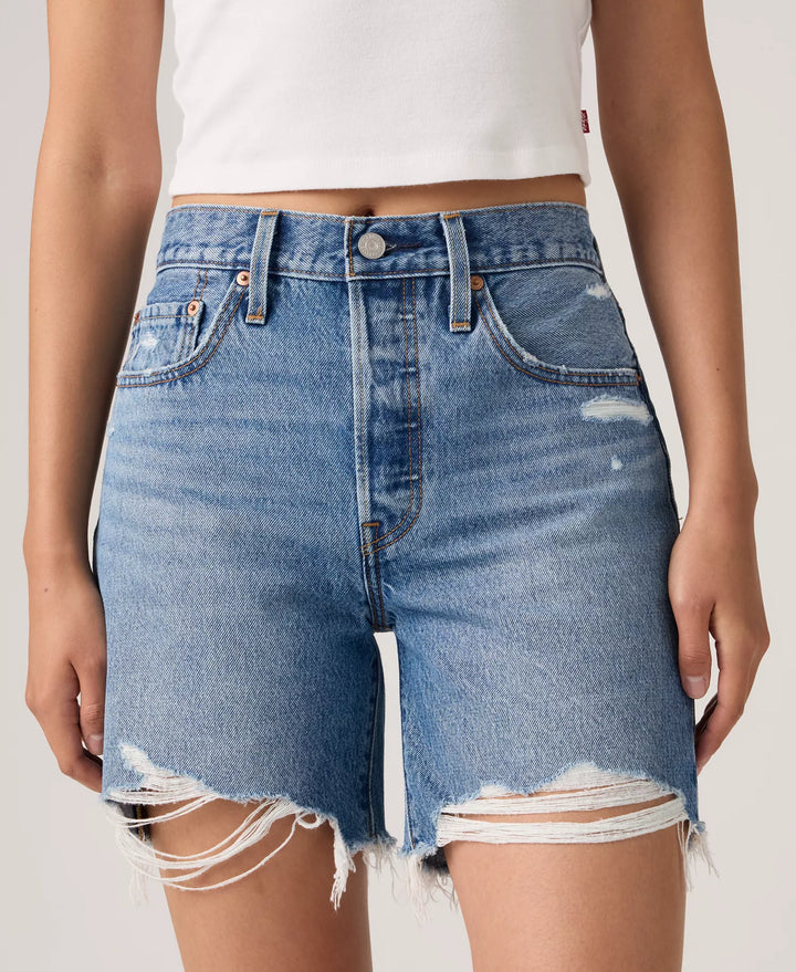 Model wears Zertz 501 MID THIGH SHORTS - BLOW BIG HORNS: vintage-inspired, high-rise jean shorts with frayed hems and distressed details, paired with a white crop top. Shown from waist to mid-thigh.