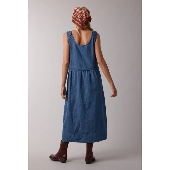 A person faces away, styled in the Zertz SLVLESS MAXI DRESS with brown boots and a red patterned headscarf—embodying effortless casual style against a plain, neutral background.