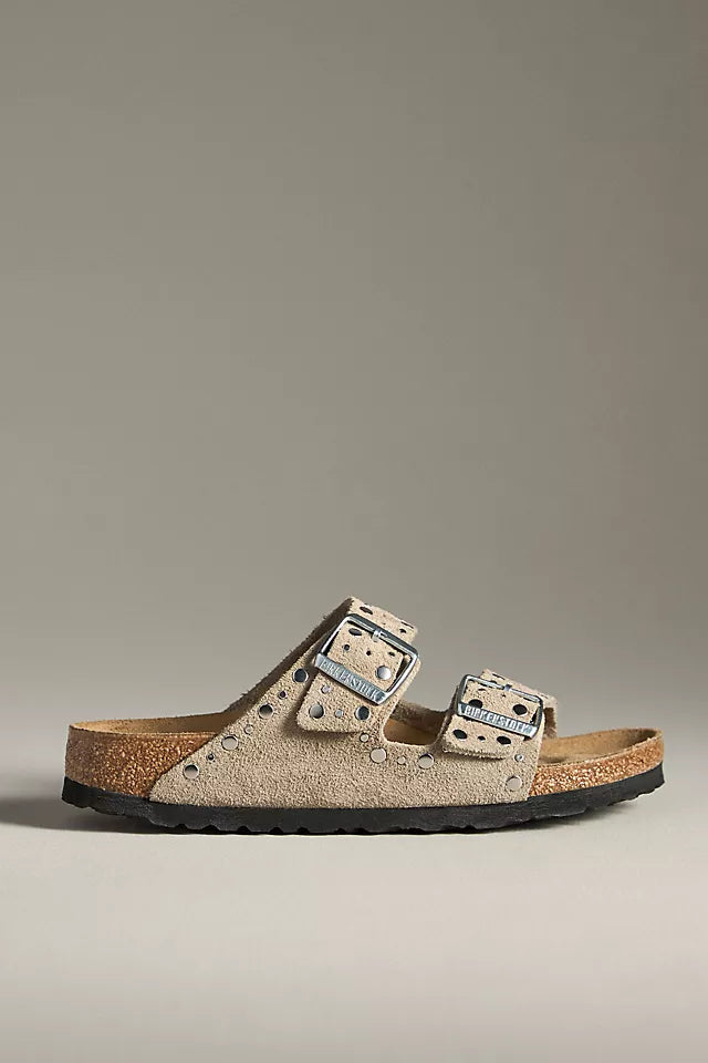 A single Zertz ARIZONA RIVET SUEDE TAUPE N sandal, featuring taupe suede, two adjustable buckle straps, metal studs, a durable cork footbed, and a black sole is displayed against a neutral background—a classic style.