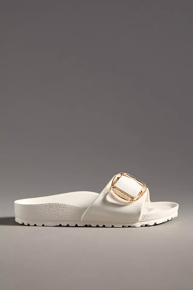 The Zertz MADRID BB EVA EGGSHELL is a white slide sandal featuring a chunky sole and oversized gold buckle on the strap, crafted from ultra-lightweight EVA, shown on a plain gray background.