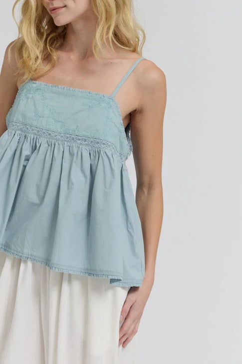 A woman models the Zertz EMBROIDERED SLEEVELESS TOP in light blue with lace details and a flowing white skirt against a plain background, creating an effortless casual look.