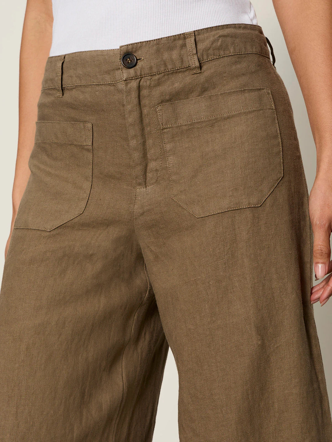 A person wears Zertz THE LINEN MARINE WIDE LEG PANT CP1043716 in brown with front patch pockets and a white ribbed tank top. Only their lower torso and upper legs are shown.