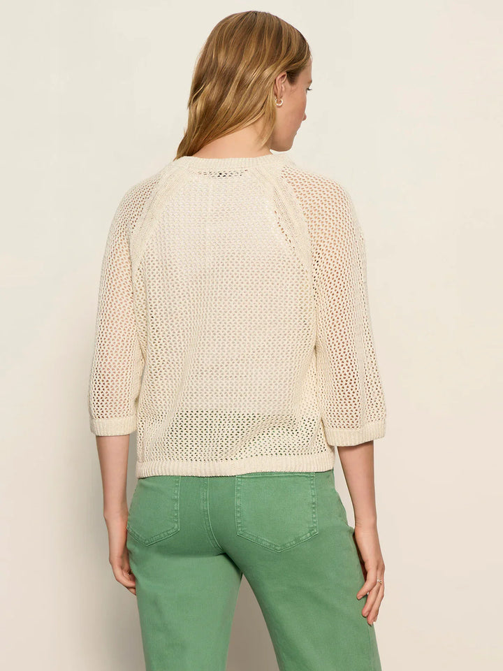 A woman with blonde hair, seen from the back, models the Zertz METALLIC SWEATER with three-quarter sleeves and light green pants against a plain, light background.