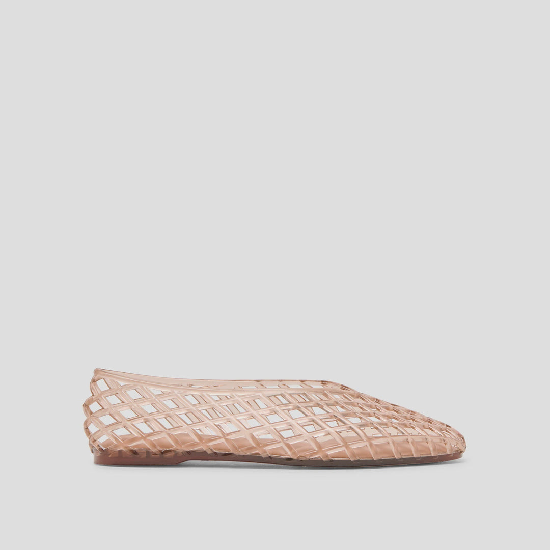 The Zertz JAM FLATS are nude-colored, translucent shoes with a woven lattice design—versatile footwear that pairs effortlessly with any outfit, shown here on a light gray background.