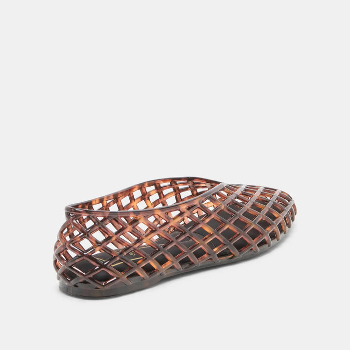 The Zertz JAM FLATS, in brown, feature a lattice basket-weave jelly design. Shown against a white background, the shoe is angled to display both its side and back views, highlighting its versatile style.