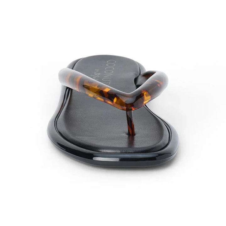The Zertz MERMAID FLIP FLOP is a black vegan PVC sandal with a glossy tortoiseshell finish and a thick V-shaped strap, shown facing forward against a white background.