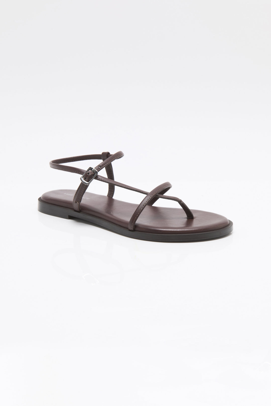The Zertz CORSICA STRAPPY SANDAL is a minimalist brown sandal with thin straps and an ankle buckle, shown on a plain white background—ideal for anyone seeking stylish, comfortable strappy footwear.