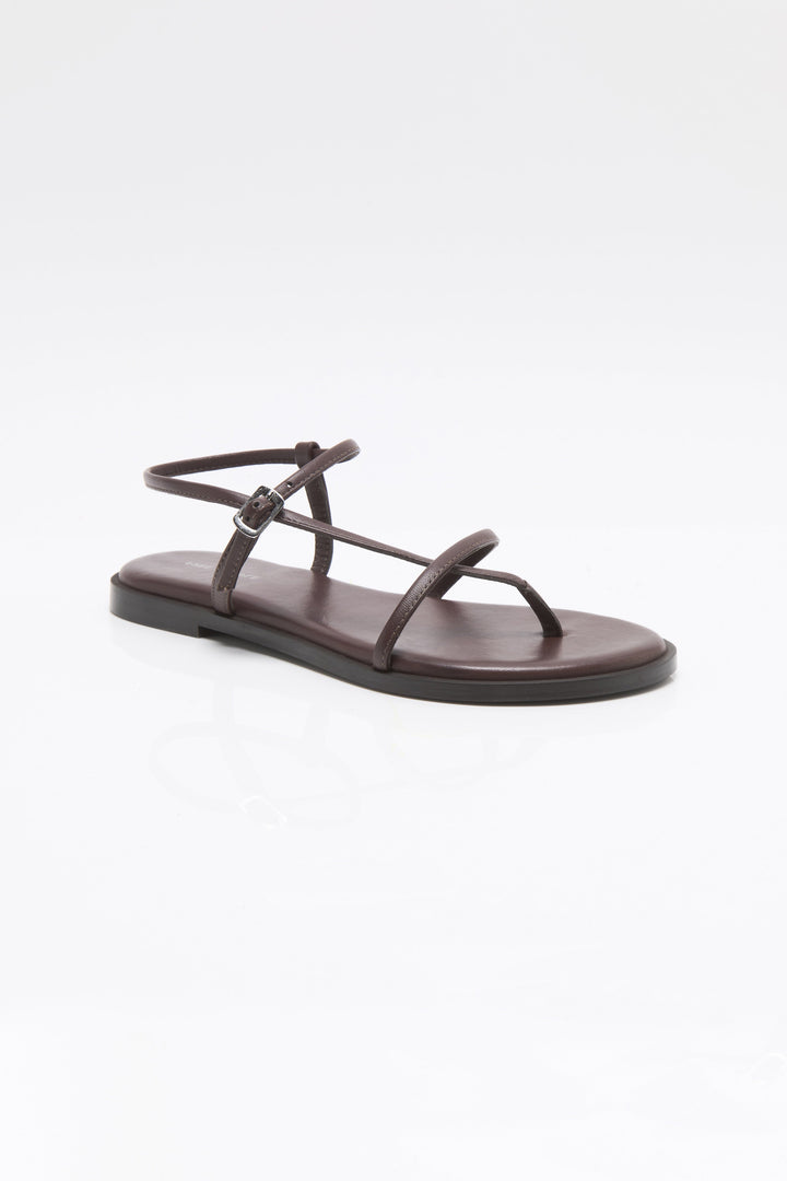 The Zertz CORSICA STRAPPY SANDAL is a minimalist brown sandal with thin straps and an ankle buckle, shown on a plain white background—ideal for anyone seeking stylish, comfortable strappy footwear.