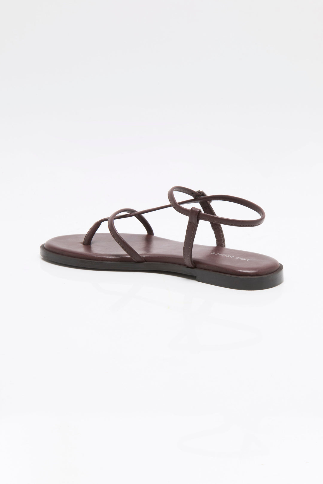 The Zertz CORSICA STRAPPY SANDAL features a minimalist brown design with thin straps and a unique circular detail, showcased on a clean white background—ideal for fans of chic, comfortable footwear.
