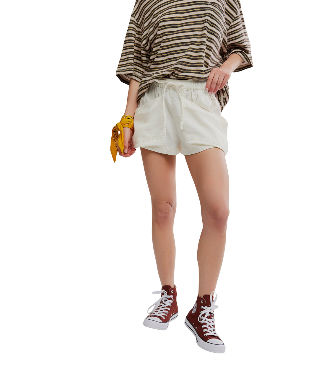 A person stands against a white background wearing the Zertz GOOD FORTUNE SHORT, a brown striped shirt, burgundy high-top sneakers, and a yellow bandana on their wrist. Their face is not visible.