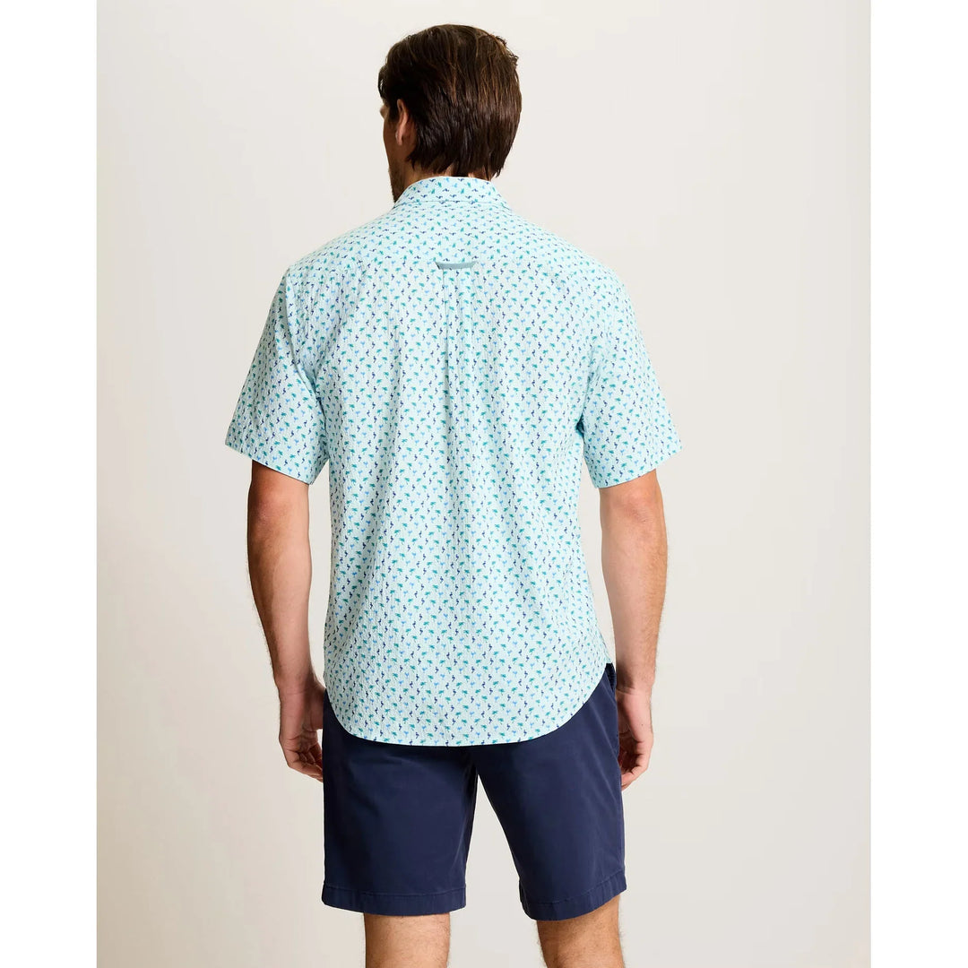 A man faces away, wearing the Zertz NOVA WAVE FLOCK IT TO YOU lightweight cotton shirt with a small red and blue pattern, paired with dark blue shorts—a relaxed, low-maintenance look for warm days against a plain light background.
