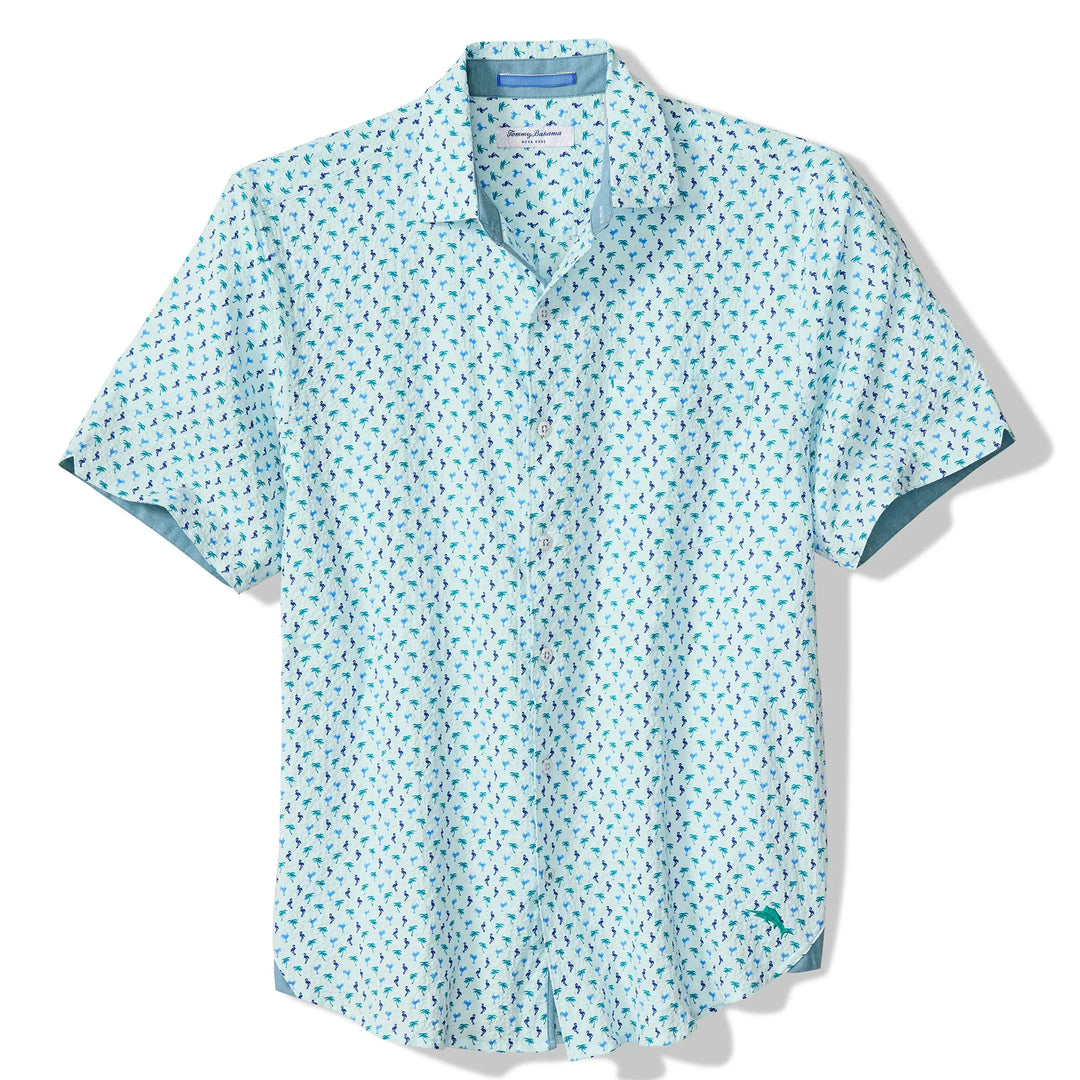 The Zertz NOVA WAVE FLOCK IT TO YOU is a light blue, short-sleeve button-up cotton shirt with a white background and a subtle green and blue palm tree print, perfect for an island-inspired look.