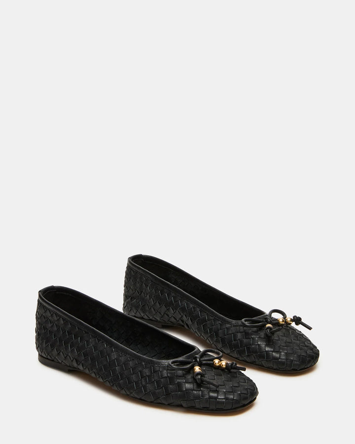 The Zertz DIVY LEATHER FLAT is a pair of black woven ballet flats featuring bow embellishments and small gold-tone beads on the front, shown against a plain white background.