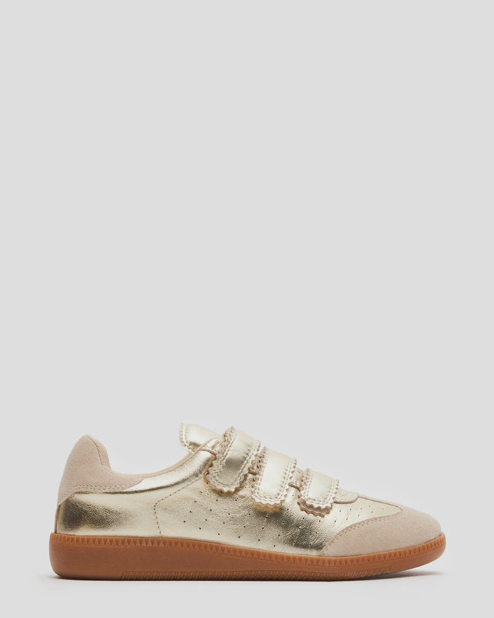 The Zertz MOMENTUM SNEAKERS are gold low-top shoes featuring three Velcro straps, beige suede accents on the toe and heel, perforated sides, and a brown rubber sole, shown against a plain light background.