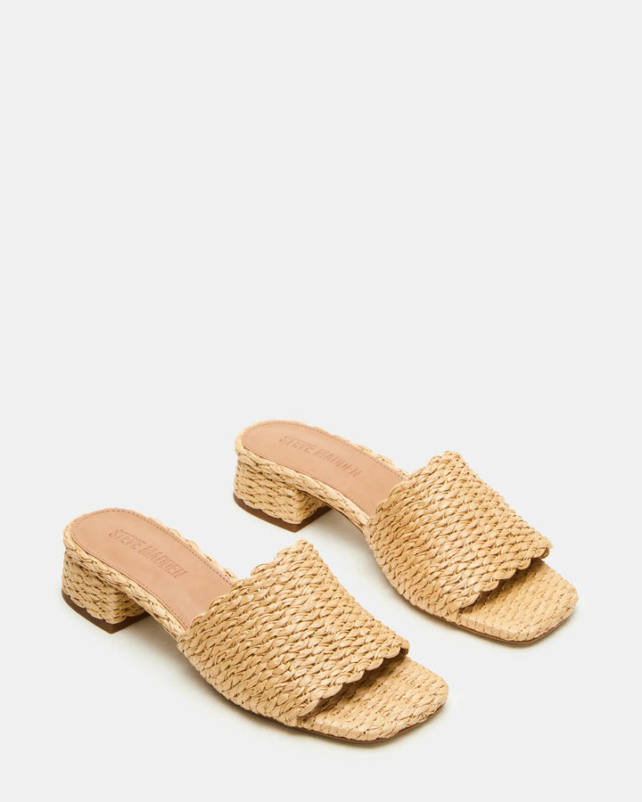 The Zertz MONTGOMERY SLIDE SANDAL features woven raffia, a low block heel, and scalloped edges, shown on a white background.