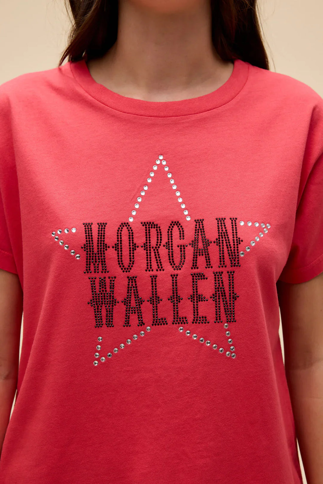 A person wearing the Zertz MORGAN WALLEN RHINESTONE STAR SOLO TEE, a red shirt featuring a silver stud star and bold “MORGAN WALLEN” western lettering, celebrates the popular country artist.