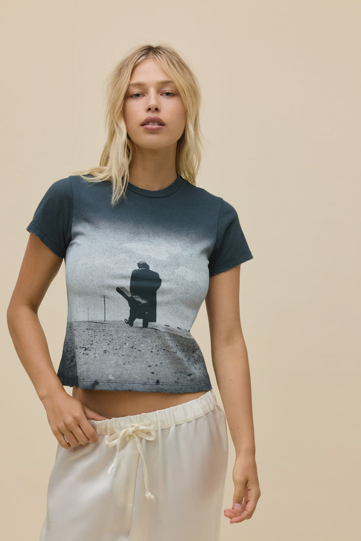 A blonde woman stands against a beige background wearing Zertz&