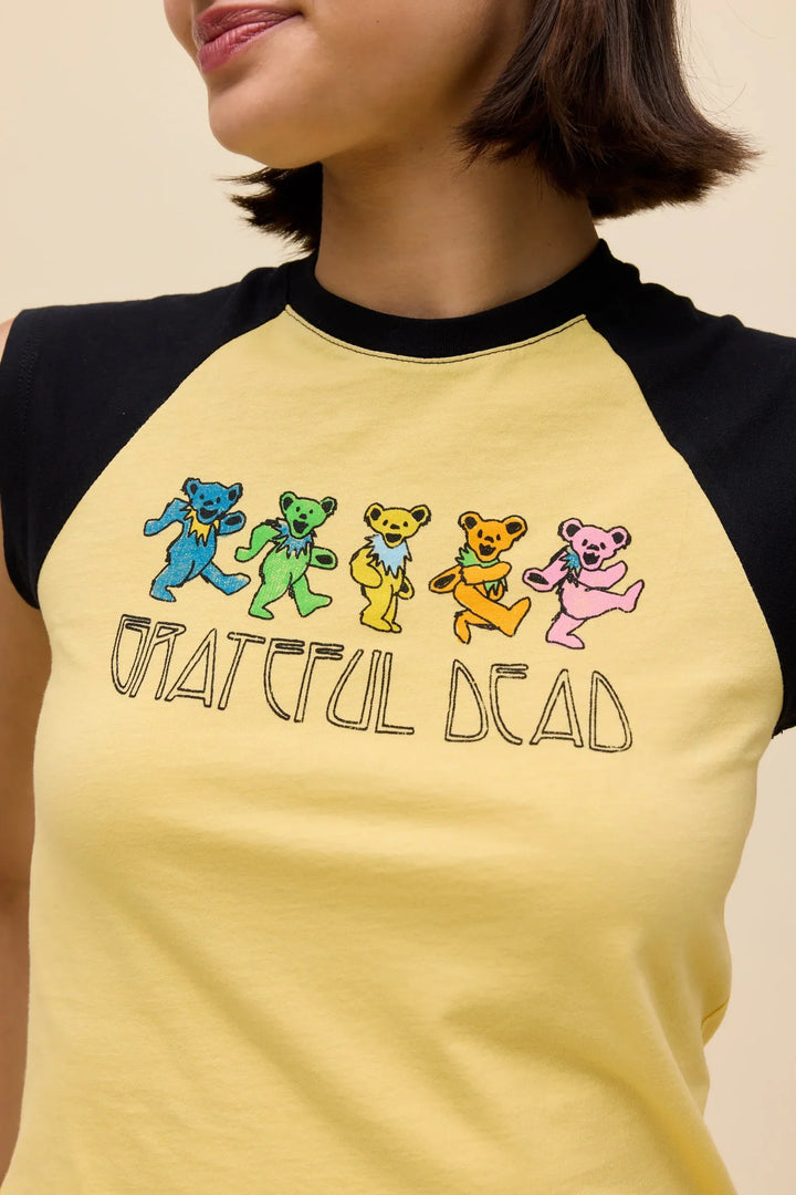 A person wearing a Zertz GREATFUL DEAD BEARS RGLAN TEE, a yellow and black raglan top featuring five colorful dancing bears and “Grateful Dead” text on the front.