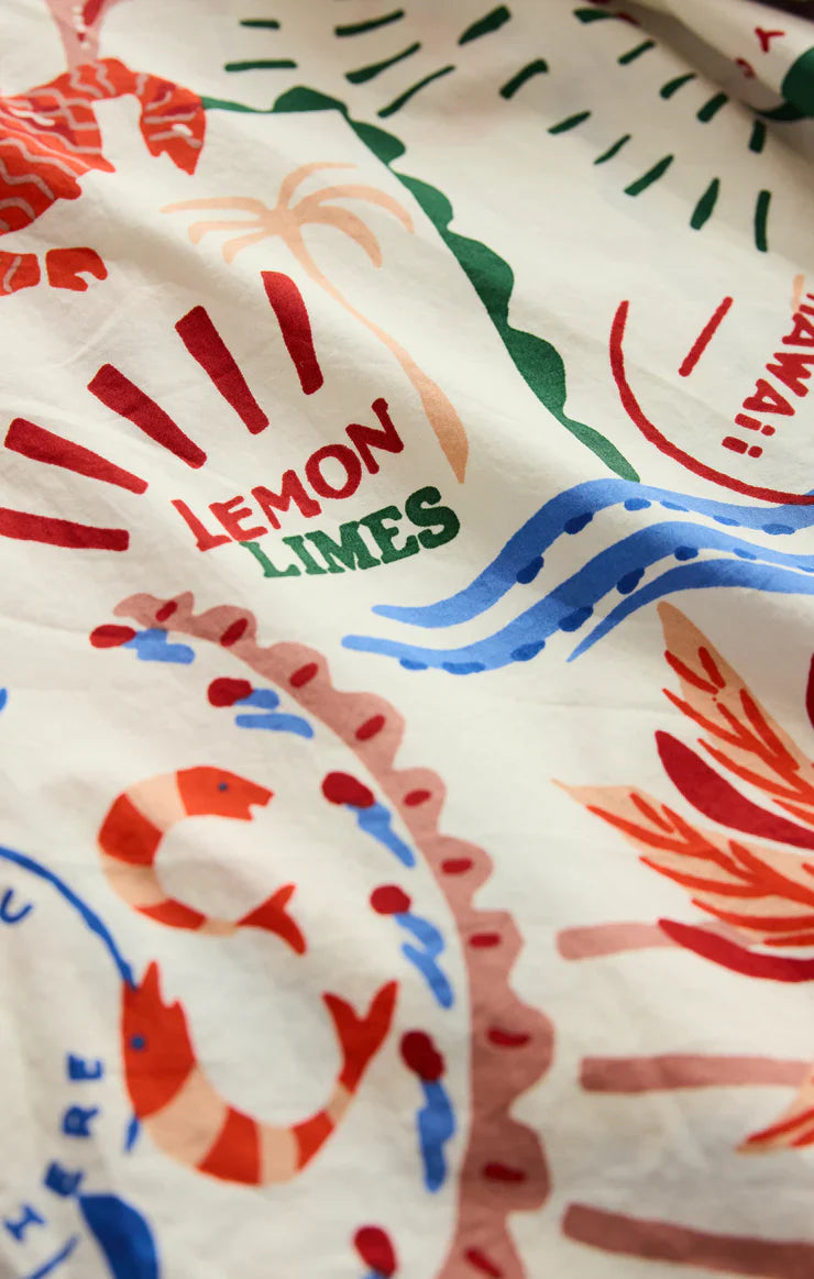 A close-up of vibrant fabric with hand-drawn seafood, leaves, and "LEMON LIMES" in red and green—ideal for Zertz&