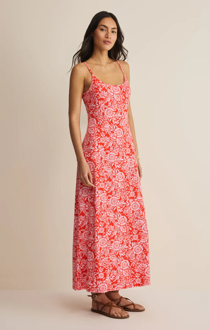 A woman poses against a plain background in the Zertz CHARISMA ONA FLORAL MIDI DRESS—an ankle-length, sleeveless red and white summer dress with adjustable spaghetti straps, perfectly styled with sandals for a relaxed look.