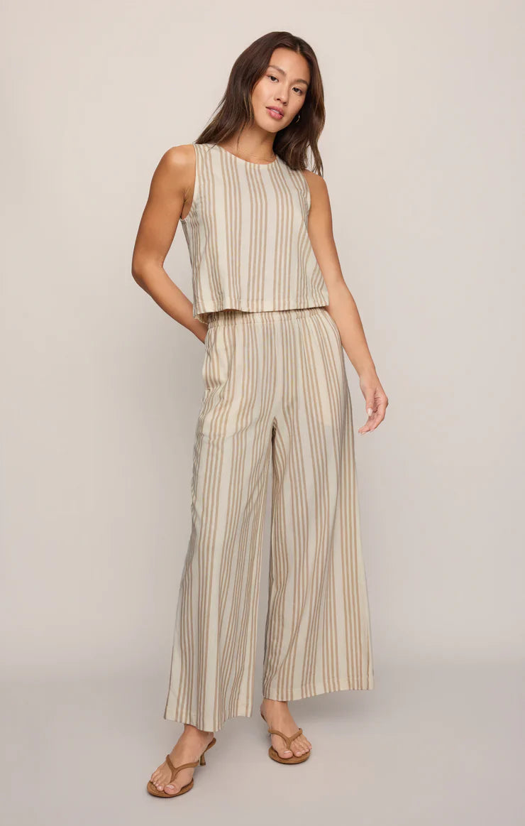 A woman models the SLOANE KNIT STRIPED TOP by Zertz, a sleeveless cotton-blend piece with vertical brown stripes, paired with matching wide-leg pants and sandals against a plain light background.