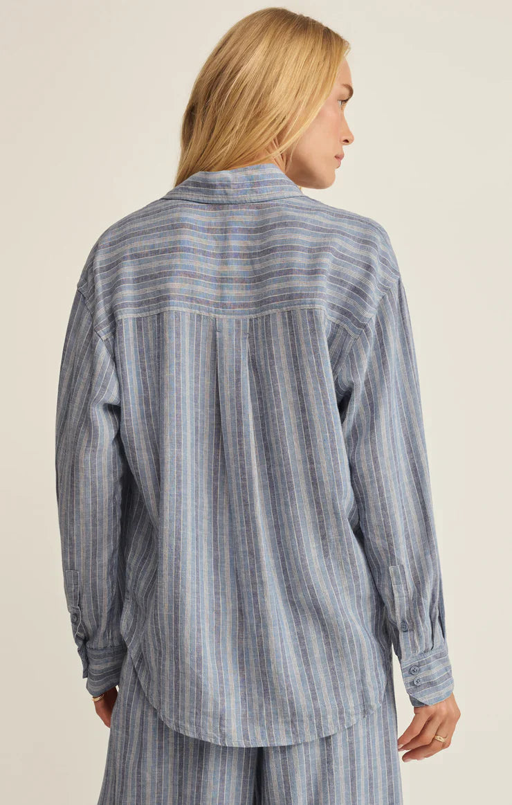 A person with long blonde hair wears the Zertz THE PERFECT STRIPED BUTTON UP ZT262689, a loose-fitting blue and white striped shirt and matching pants, shown from the back against a neutral background.
