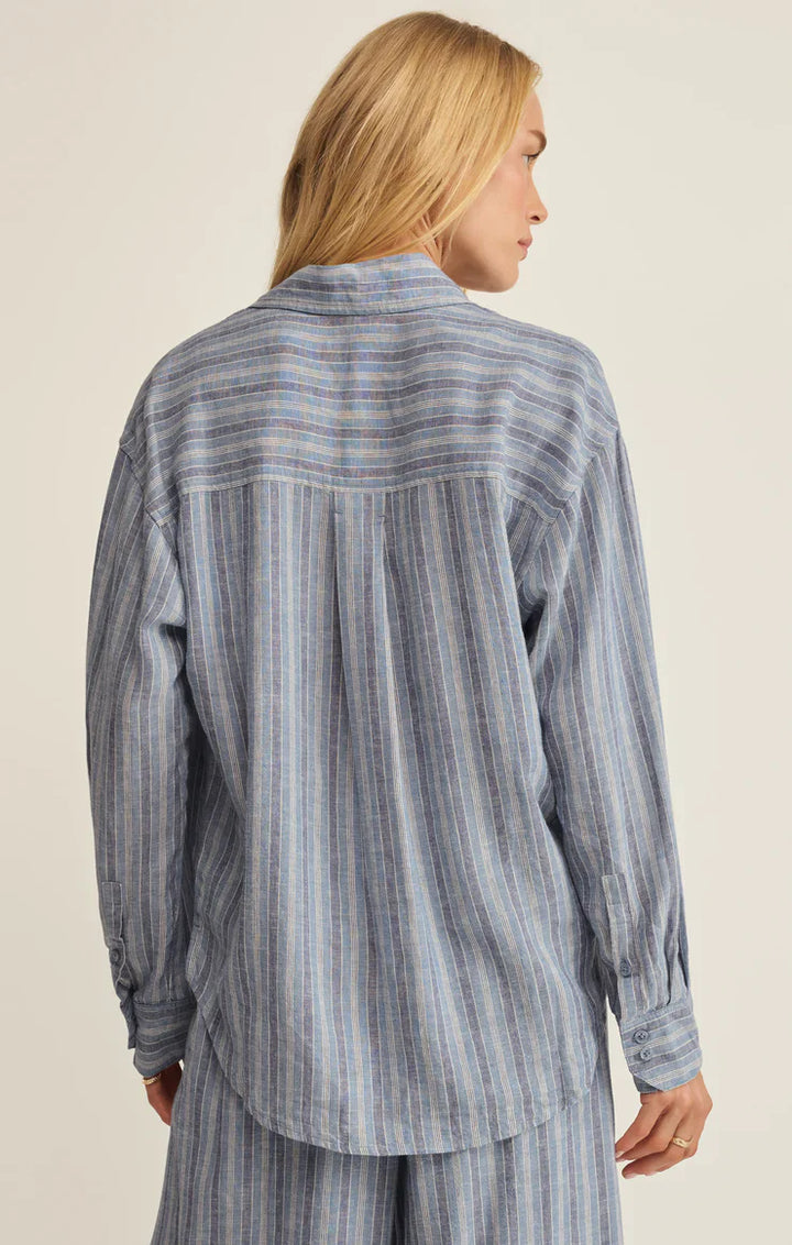 A person with long blonde hair wears the Zertz THE PERFECT STRIPED BUTTON UP ZT262689, a loose-fitting blue and white striped shirt and matching pants, shown from the back against a neutral background.