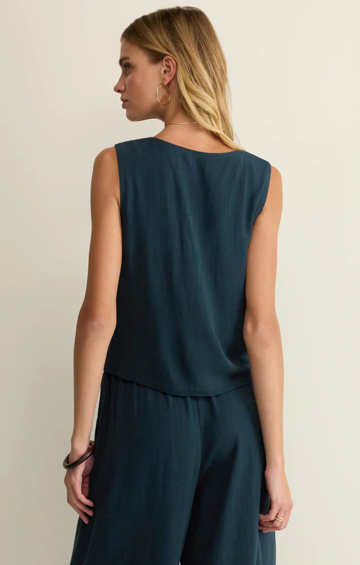 A woman with long blonde hair is seen from the back, wearing the Zertz CHARLI TOP and matching wide-leg pants in dark teal, standing against a plain light background.