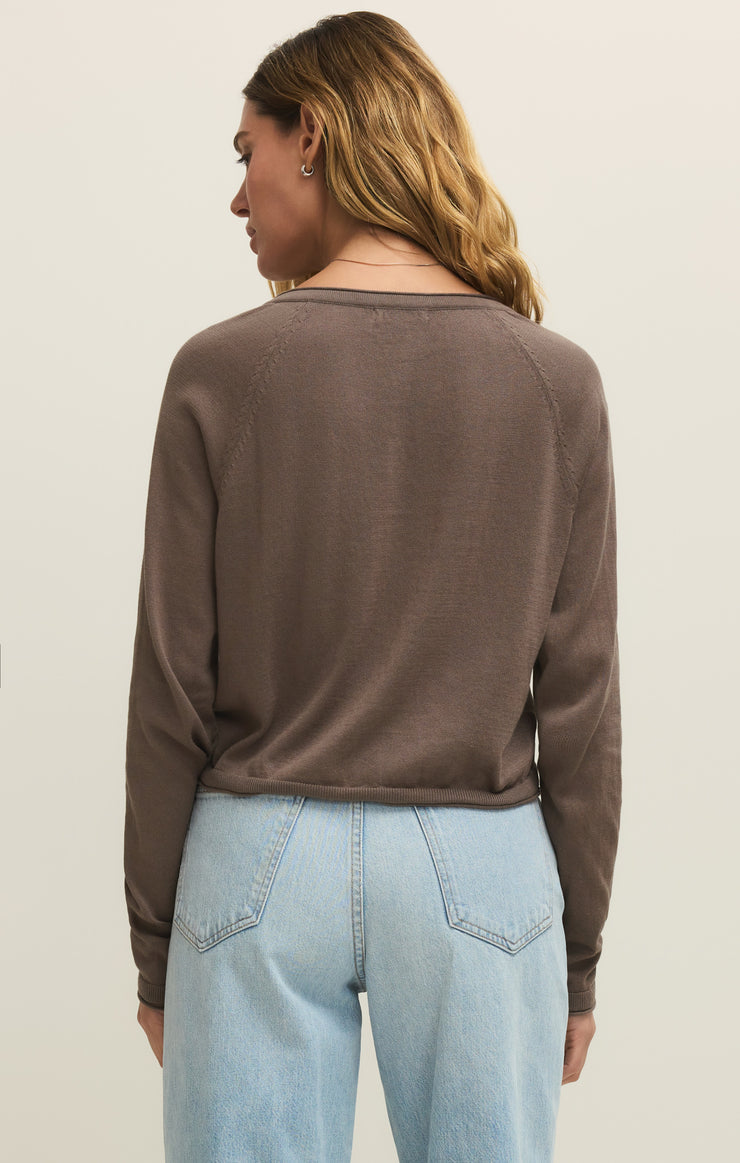 A woman with wavy light brown hair, seen from the back, wears the Zertz THE PERFECT LAYER CARDIGAN in Perfectly Taupe (ZW261179) and light blue high-waisted jeans, standing against a plain light background.