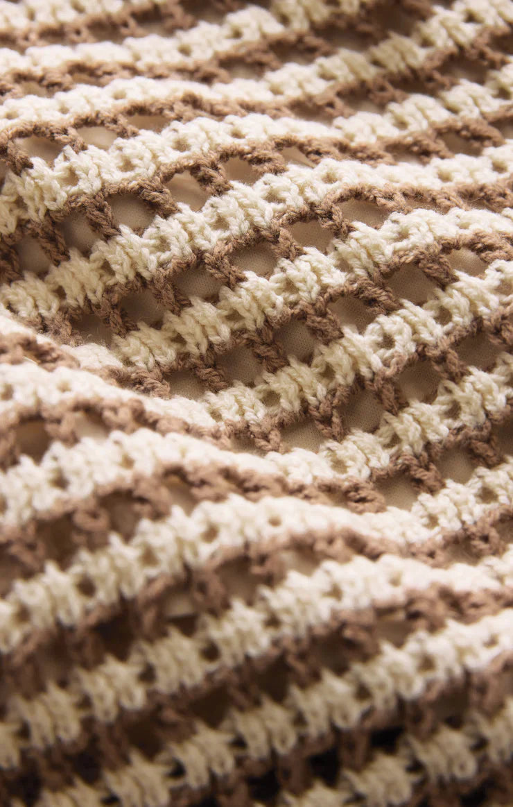 Close-up of the KYLO STRIPED SWEATER by Zertz, featuring a lightweight crochet-knit in beige and light brown stripes with an open, wavy lattice pattern and airy gaps between stitches.