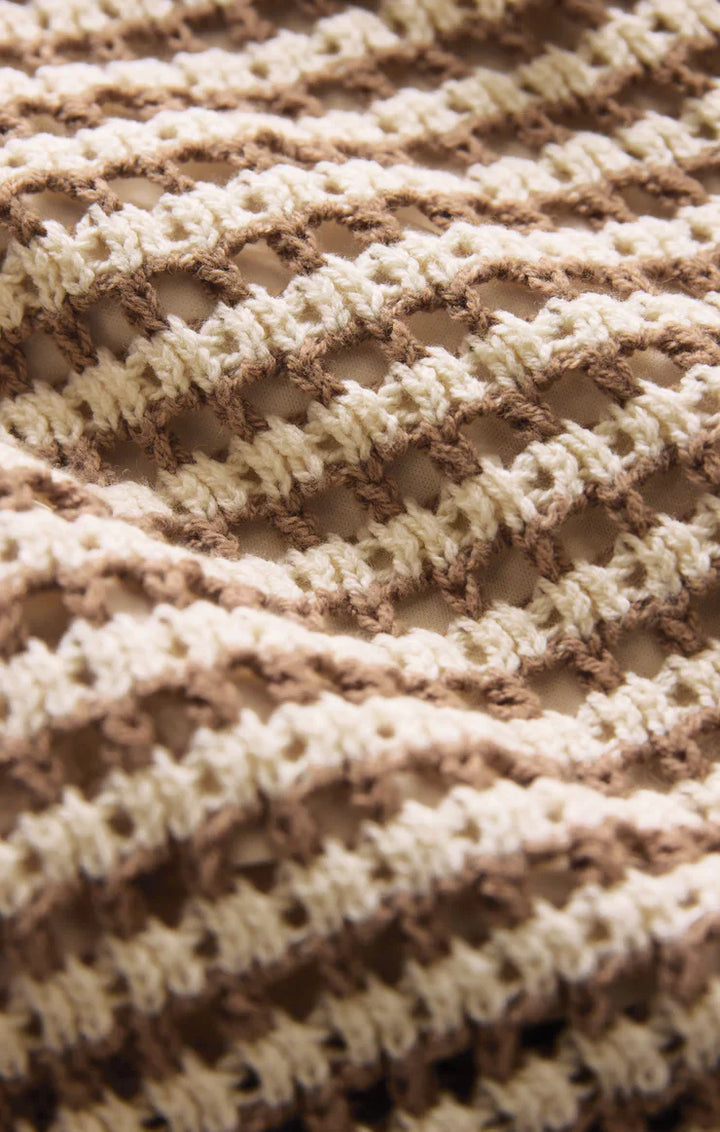 Close-up of the KYLO STRIPED SWEATER by Zertz, featuring a lightweight crochet-knit in beige and light brown stripes with an open, wavy lattice pattern and airy gaps between stitches.