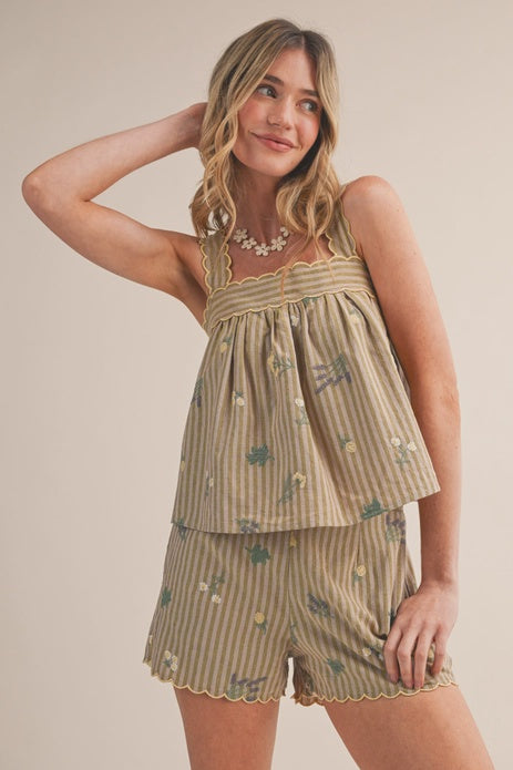 A woman smiles with one hand in her hair, wearing the Zertz FARMERS MARKET SHORT SET MPST4474—a matching sleeveless top and shorts featuring tan and green stripes with small floral prints—against a neutral background.