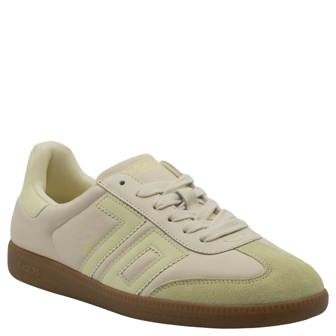 The Zertz CLOUD D26 BUTTER YELLOW SNEAKER features beige and light yellow pastels, a suede toe, leather panels, and a brown rubber sole—stylishly captured at an angle on a white background, perfect for luxe streetwear.
