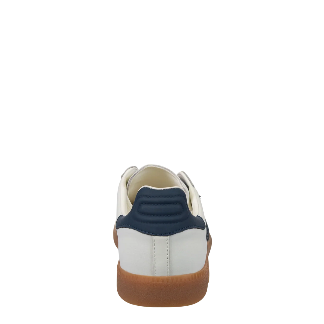 The Zertz CLOUD IN NAVY SNEAKER showcases a white upper, navy blue heel accent, and brown gum sole in a subtle color block design, shown from the back on a plain white background.