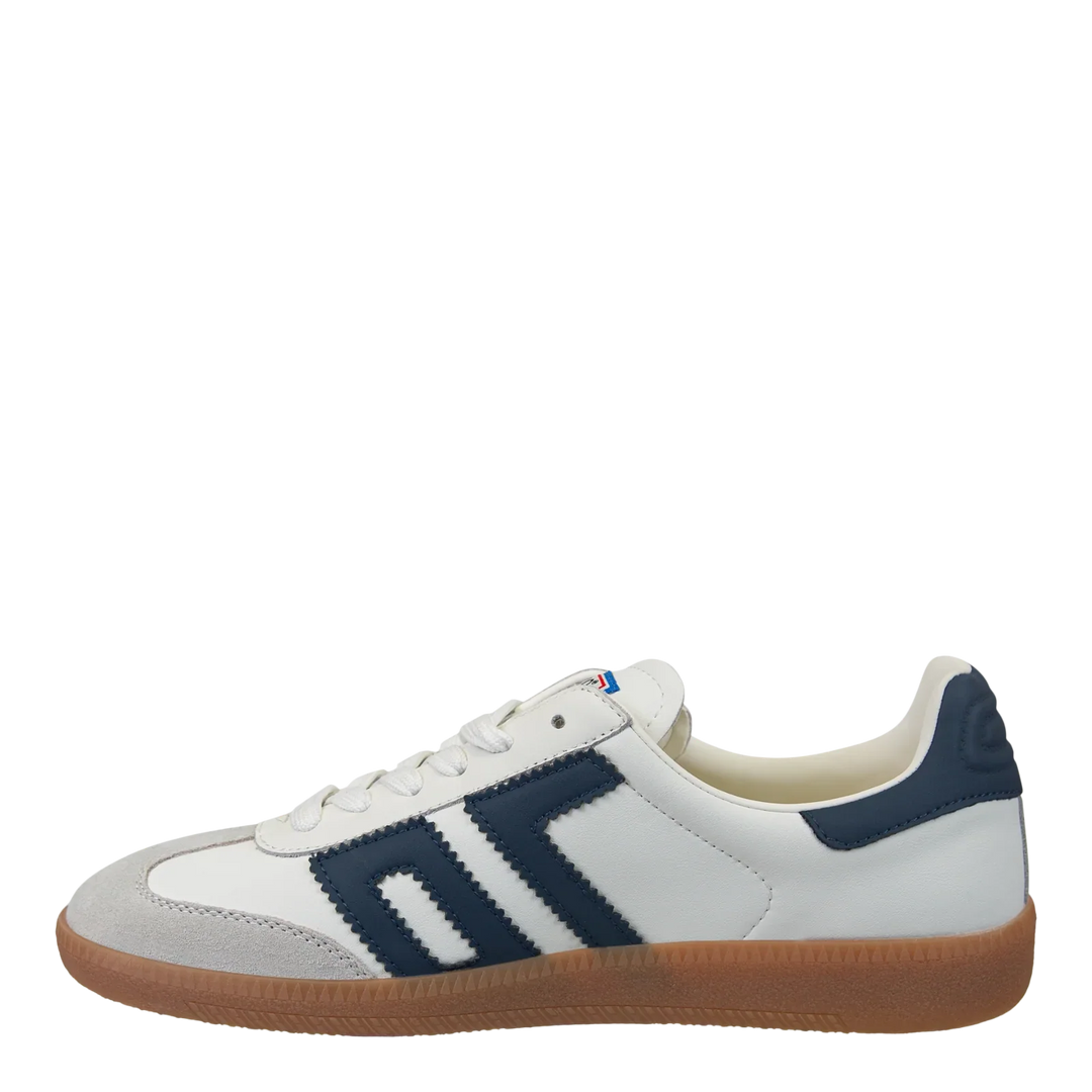 The Zertz CLOUD IN NAVY SNEAKER is a white street style shoe with navy stripes, a navy heel detail, and a gum rubber sole. Its subtle color block design is displayed in side profile against a plain white background.