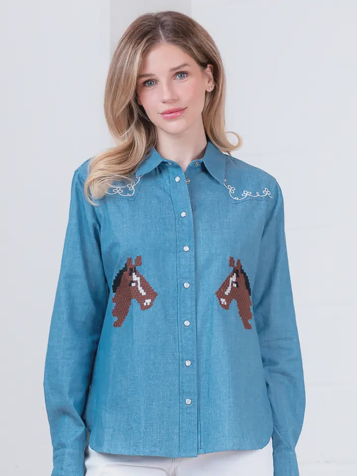A woman with long blonde hair models the Zertz DENIM EMBROIDERY TOP, a classic button-up featuring horse embroidery on the front and white-stitched collar, standing against a plain light background.