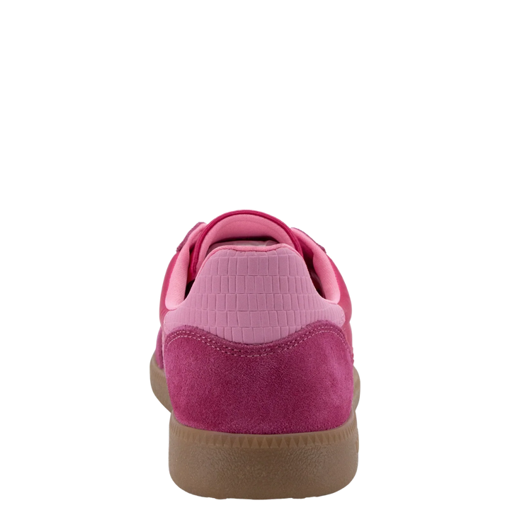 The Zertz GHOST C26 IN FUXIA SNEAKER features a pink suede handcrafted design, a textured light pink heel panel, and a brown rubber sole for a casual sporty style, shown from the rear against a plain white background.