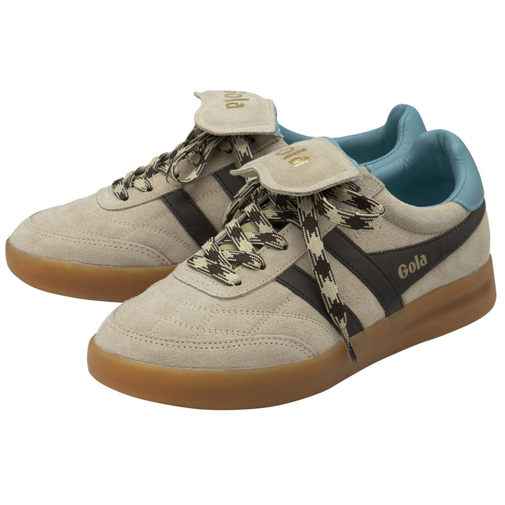 A pair of Zertz STADIA 86 TRAINER sneakers in bone suede with mocha stripes, gold branding, gum soles, ocean blue lining, and black-and-beige patterned laces. The vintage football silhouette is accented by a gold logo on the tongue.