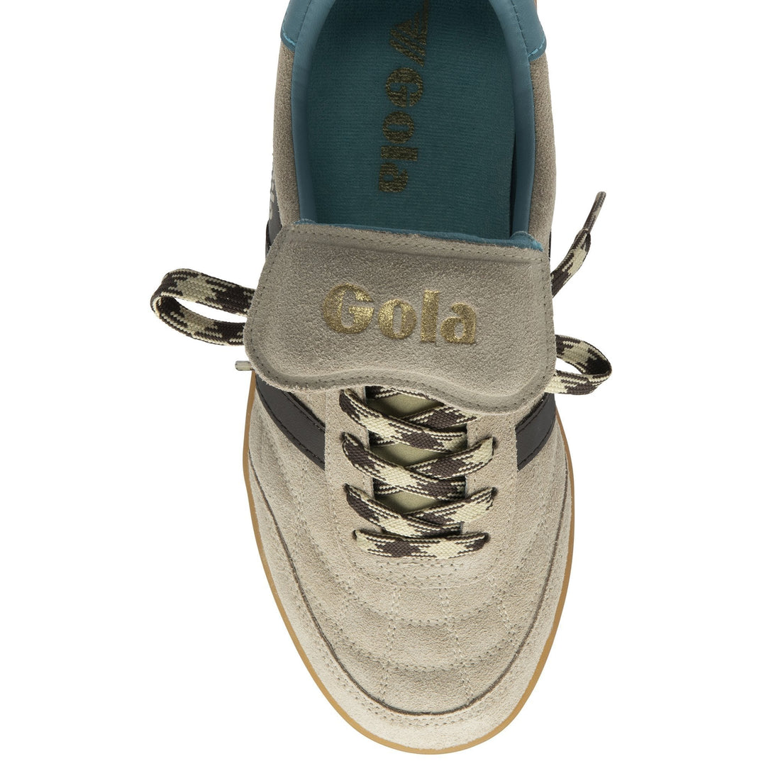 Top view of the Zertz STADIA 86 TRAINER in Bone/Mocha/Ocean/Gum, displaying a vintage football-inspired silhouette, beige upper with gold branding on the tongue, black and beige zigzag laces, teal insole, and gum-colored sole.