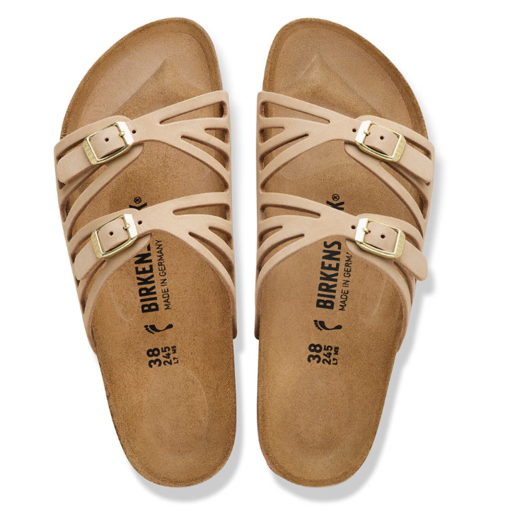 A pair of Zertz GRANADA LENB SANDCASTLE R sandals with two adjustable gold-buckle straps, crafted from nubuck leather. Featuring stylish cutouts and a contoured cork footbed, these beige sandals offer a natural look on a white background.