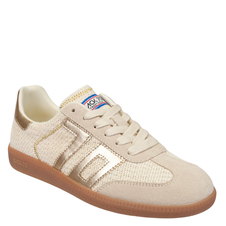 The Zertz IUTA 2512 GOLD SNEAKER is a beige and gold shoe with a gum sole, mesh and suede panels, beige laces, and a blue, white, and red TACY Exacto label on the tongue. Soccer-inspired design.
